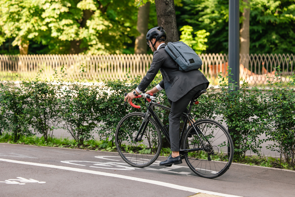 Person i kostym som cyklar.