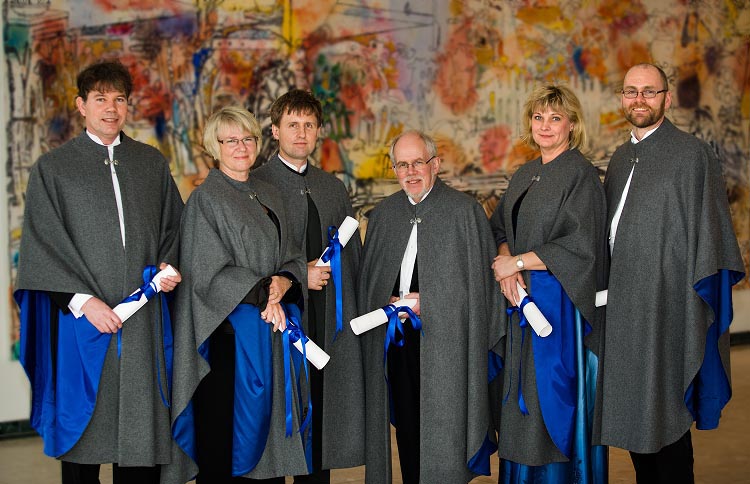 Sex personer med cape och diplom står uppradade. Foto.