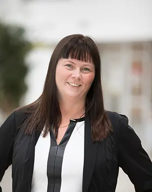 Leende kvinna med mörkt hår. Foto