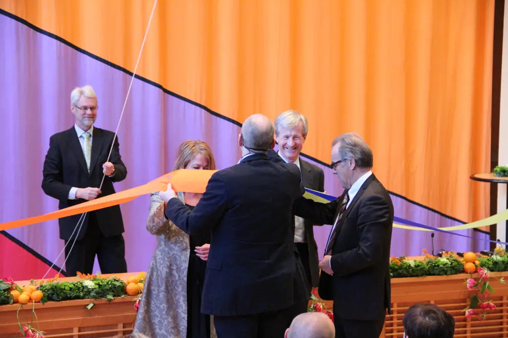 Personer som klipper ett band för en invigning. Fotografi. Foto