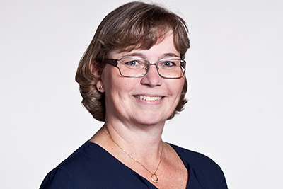 En person ler och tittar in i kameran. Foto
