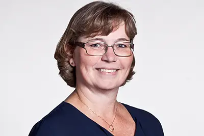 En person ler och tittar in i kameran. Foto