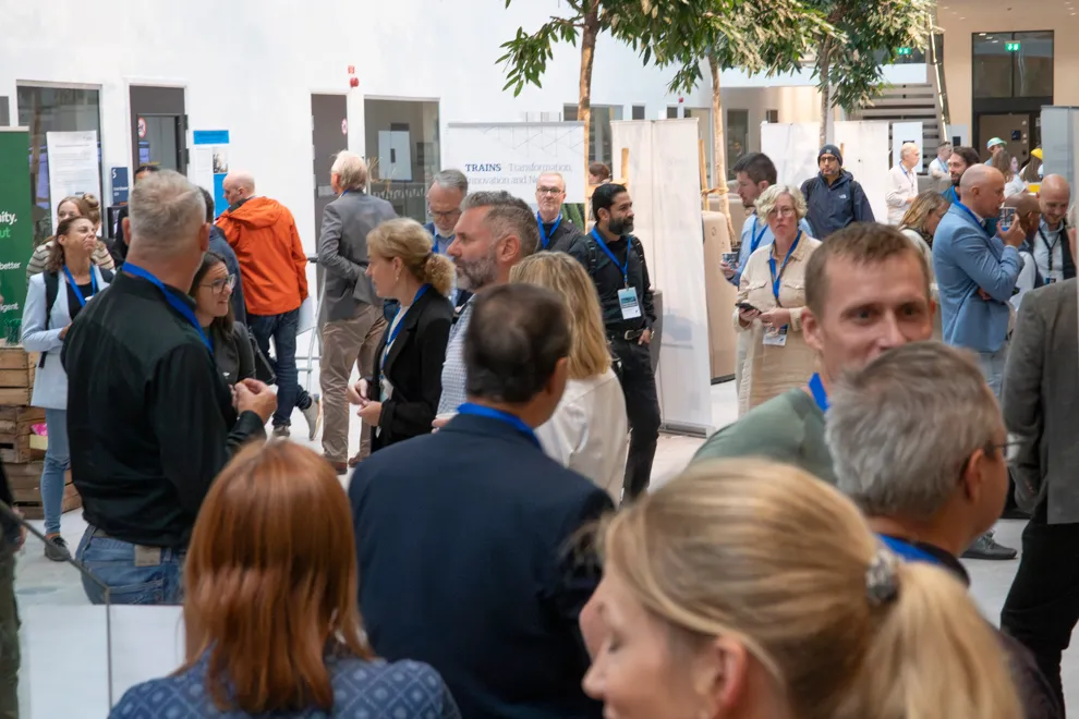 En samling människor som står runt varandra och pratar. Foto
