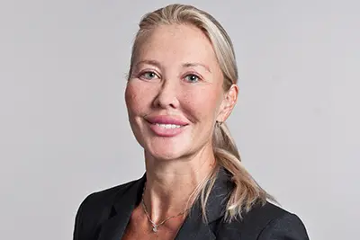 En person tittar in i kameran och ler. Foto