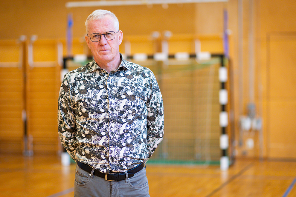 En man som står i ett gym med händerna i fickorna.