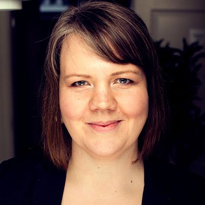 Porträtt av en leende person med långt hår. Foto