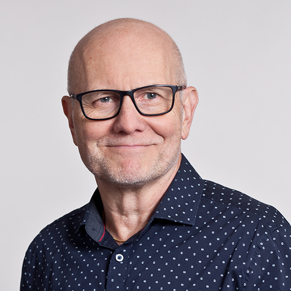 Porträttbild på leende man med glasögon. Foto.