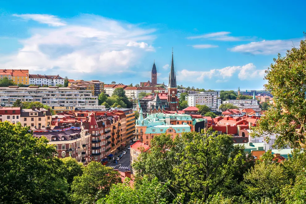 Göteborgs stadssiluett med kyrktorn och grönska.