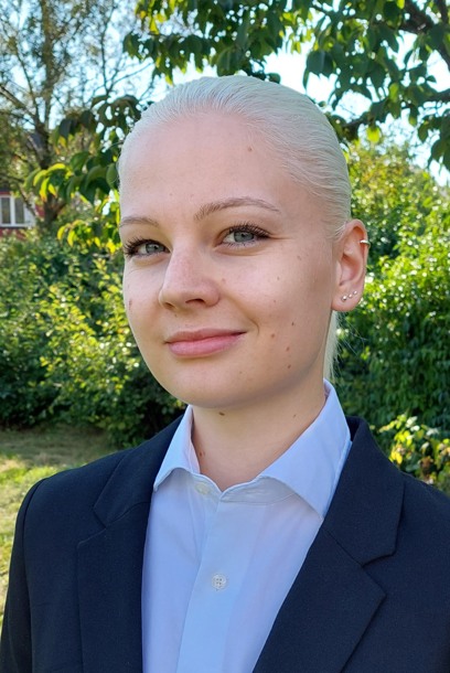 Portrait of a person with blonde hair and a black jacket. Photograph.