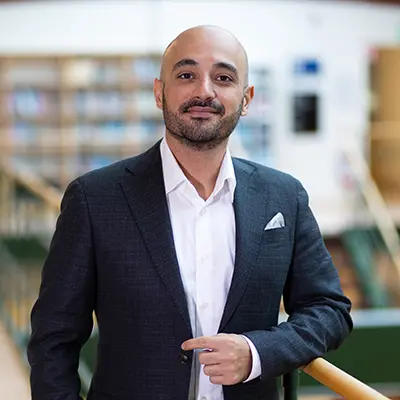 Porträtt av en leende person med långt hår. Foto