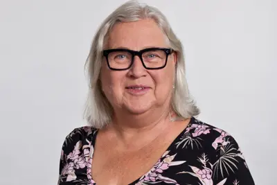Portrait of Marie Åkesson with grey hair and glasses