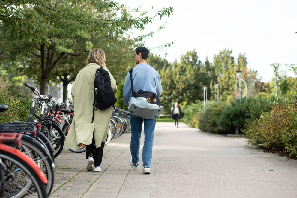 Två personer går på en cykelbana, bort från kameran. Foto