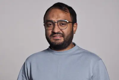 Man in glasses looking at the camera. Photo.