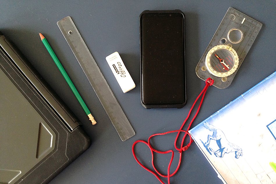 A tablet, pencil, ruler, eraser, smartphone, compass and notebook laying on a table. Photo.