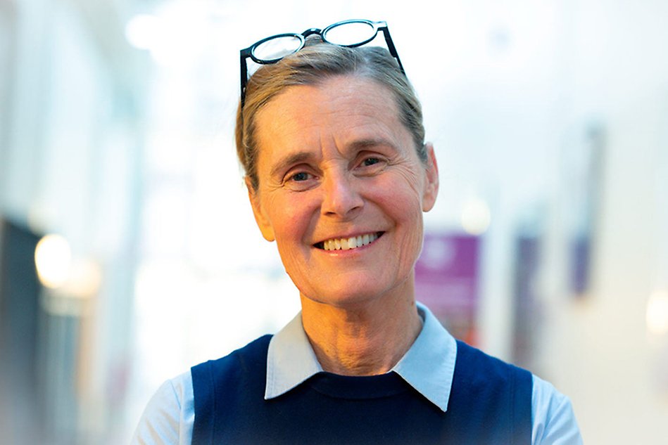A person in blue clothes smiling. Portait photo.
