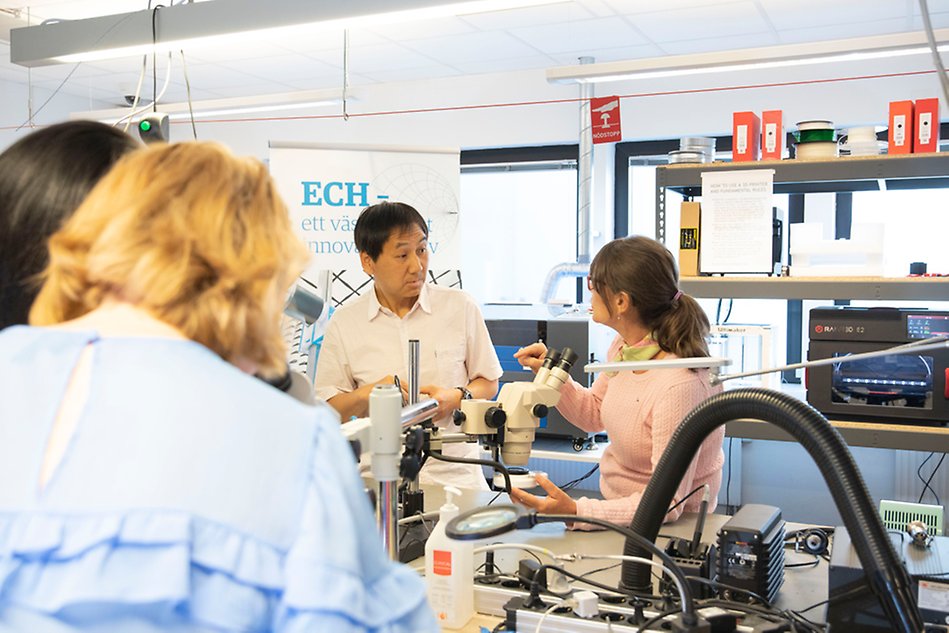 Två personer interagerar i ett elektroniklabb.