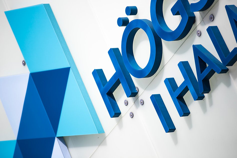 Närbild av högskolans logotyp som skylt. Foto.