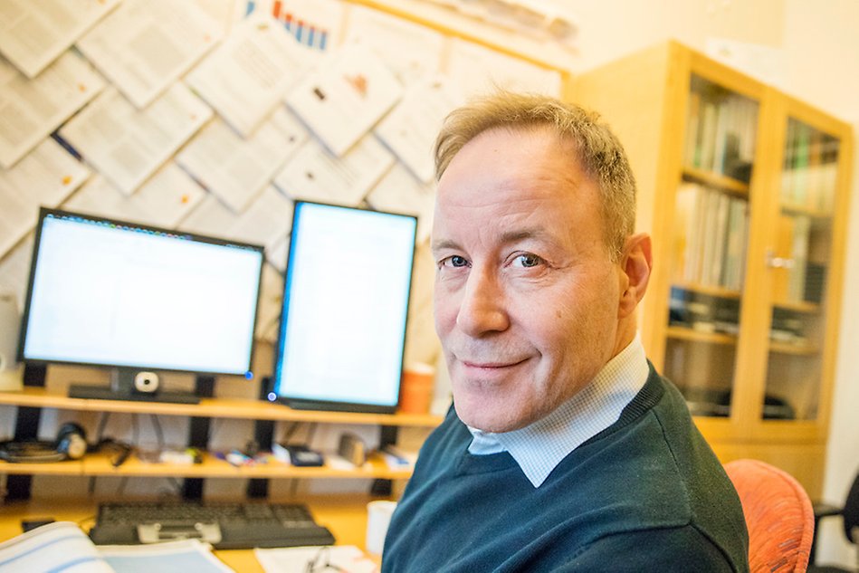 Portrait on a man in an office, facing away from a computer screen