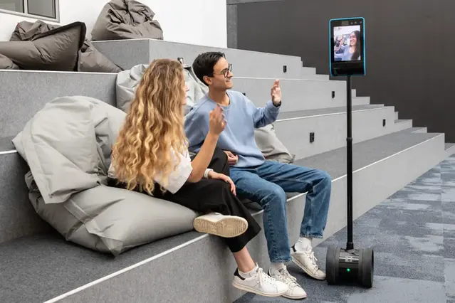 Två studenter interagerar med en mobil digital skärm.