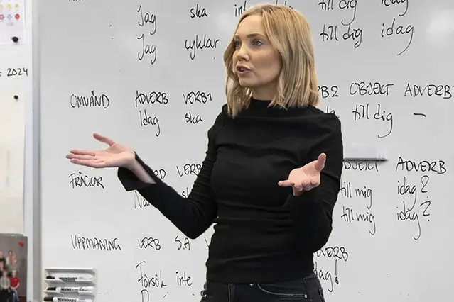 En person presenterar framför en whiteboard.