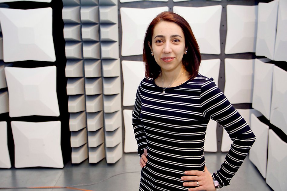 A woman is standing in an electronics testing chamber. Photo.