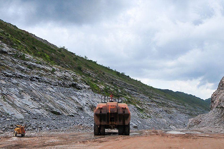 An orange excavation machine is standing in a quarry.