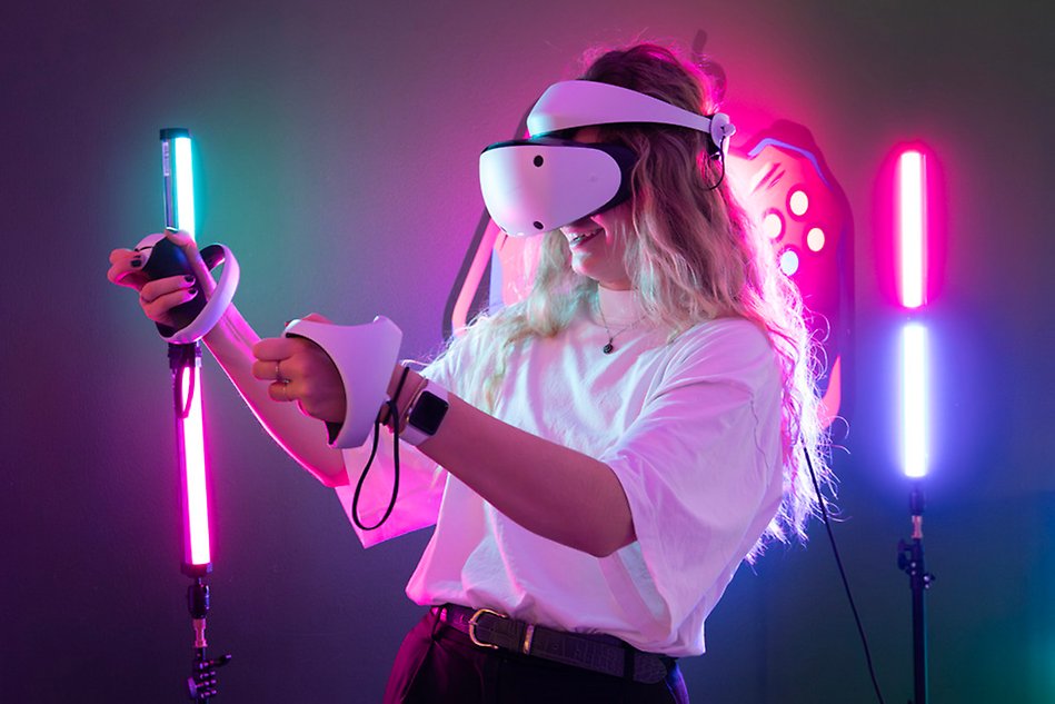 Tjej som spelar tv-spel med VR-glasögon i ett rum med färgade lysrör