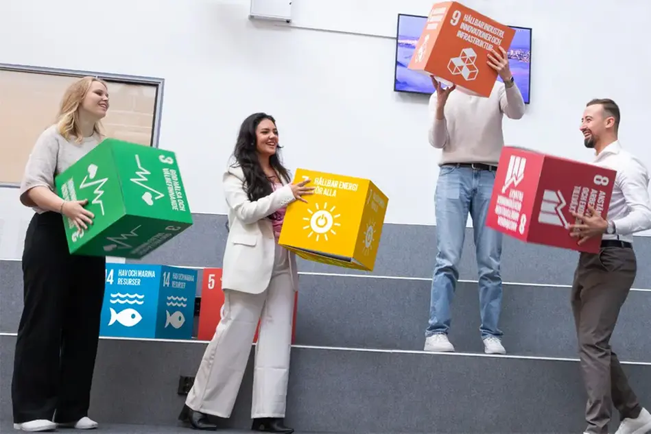 Studenter håller i kuber med globala mål. Foto.