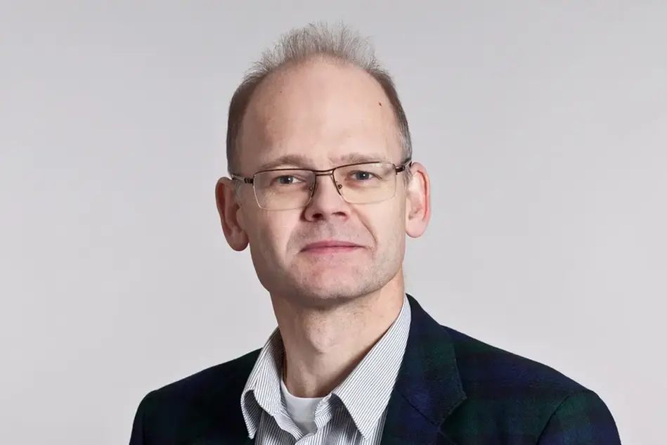 Portrait photo of a man with glasses and dark blonde hair. Photo.
