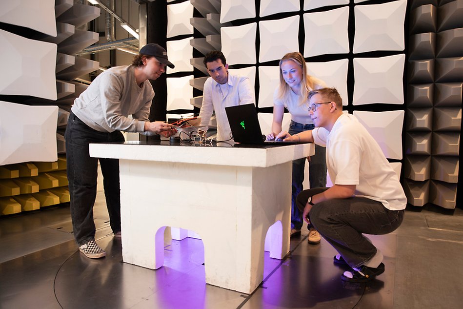 En grupp människor står i en ljudisolerad testkammare.