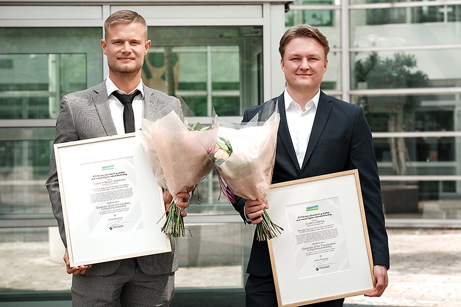 Två personer i kostym håller upp diplom och blommor för att de fått PS Providers stipendium. Foto.