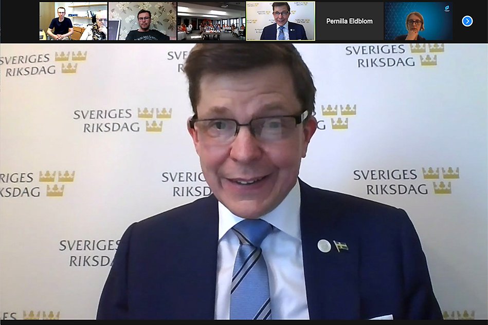 man i glasögon, kavaj, på bakgrunden står det Sveriges riksdag