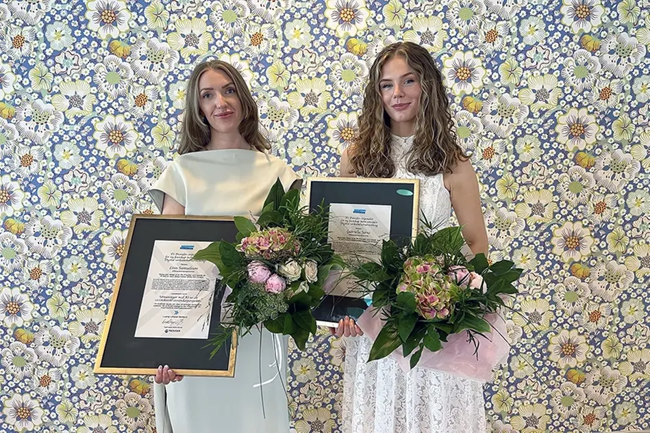 Två personer i klänning håller upp diplom och blommor för att de fått PS Providers stipendium. Foto.