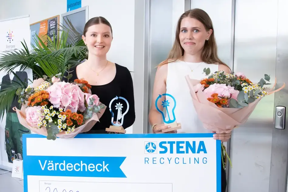Två studenter tittar in i kameran. De håller i blommor, statyett och värdecheck.