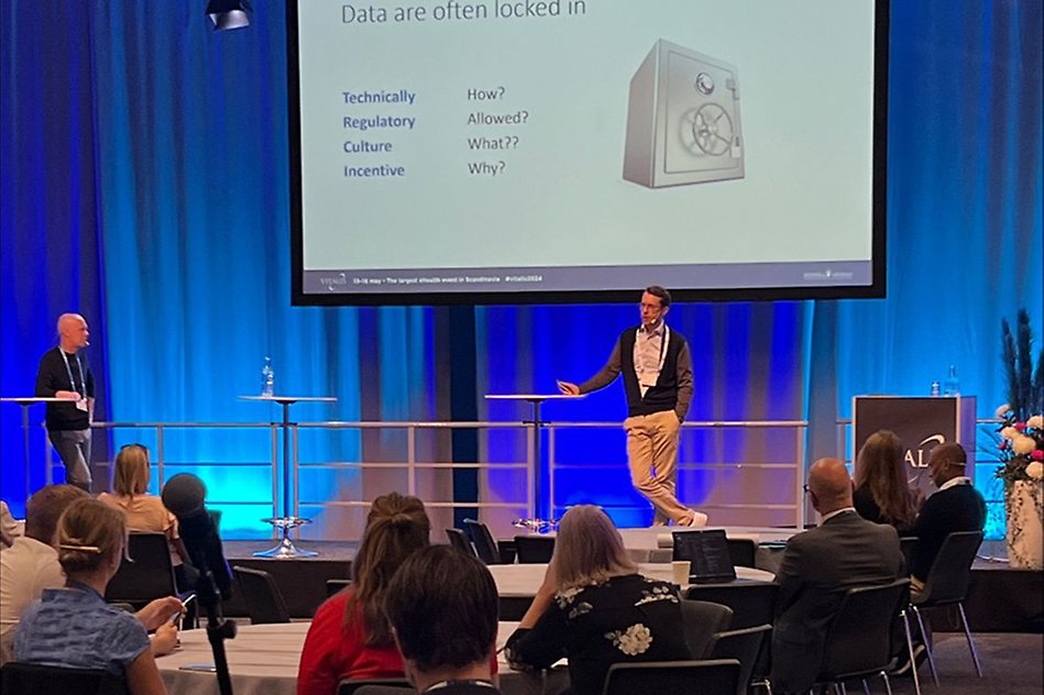 A man is presenting at a conference.