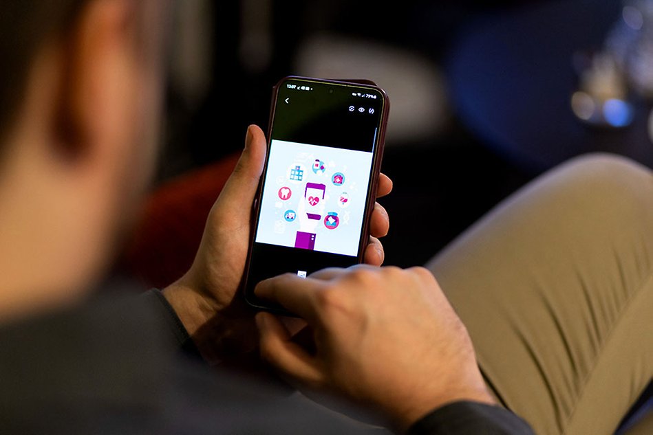 A man is demonstrating an application on a mobile phone.