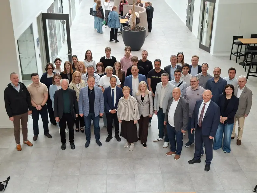 Gruppbild på ett 40-tal person som ler mot kameran