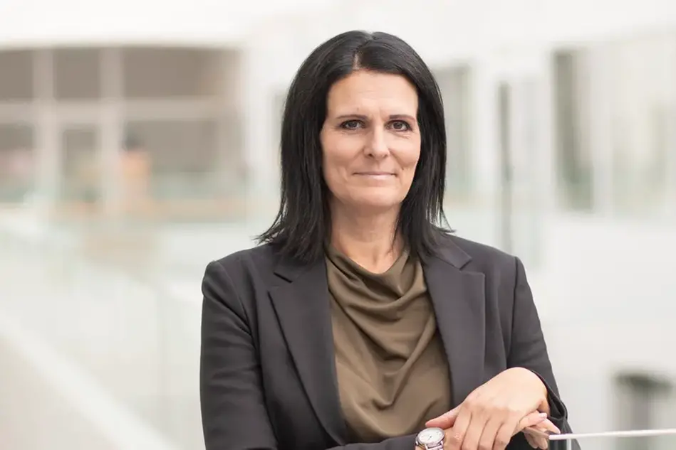 En person ler och tittar in i kameran. Foto