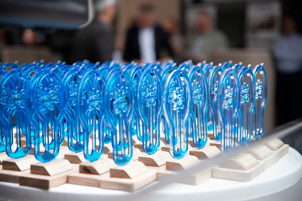 Dozens of blue Utexpo statuettes on a table.