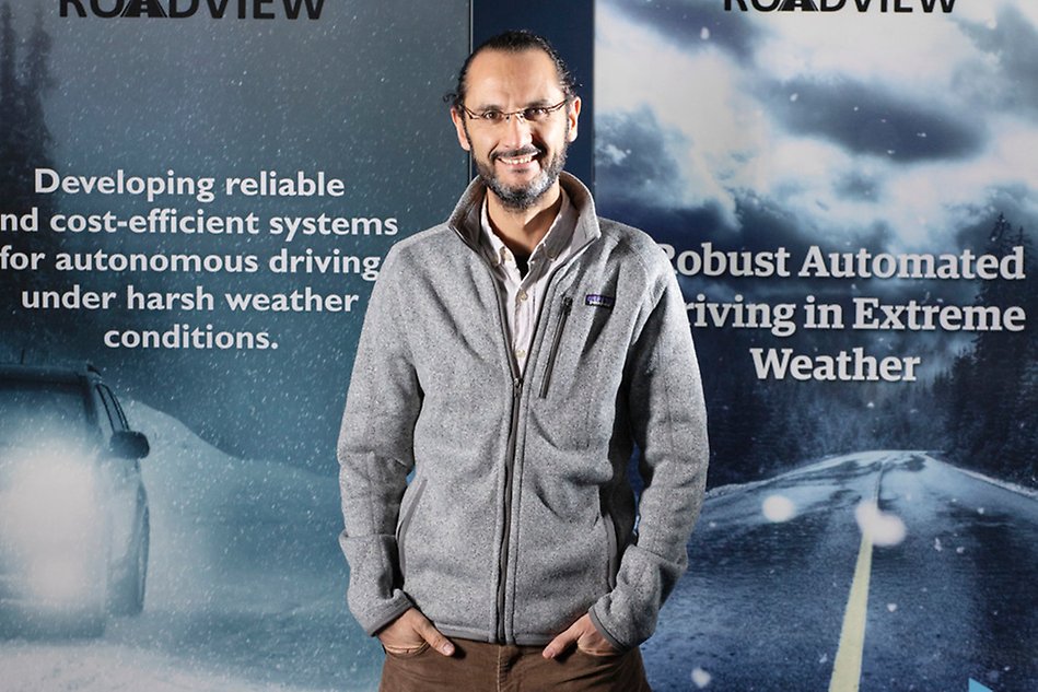 A man stands in front of two roll-ups that says ROADVIEW on them. 