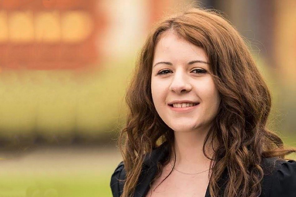 A portrait of a smiling brown haired woman. Photo.