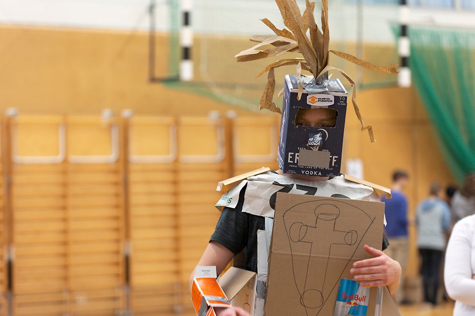 A person in armour made of cardboard boxes. 