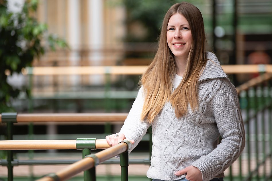 Fem studenter står med cyklar framför Högskolans entré. Foto.