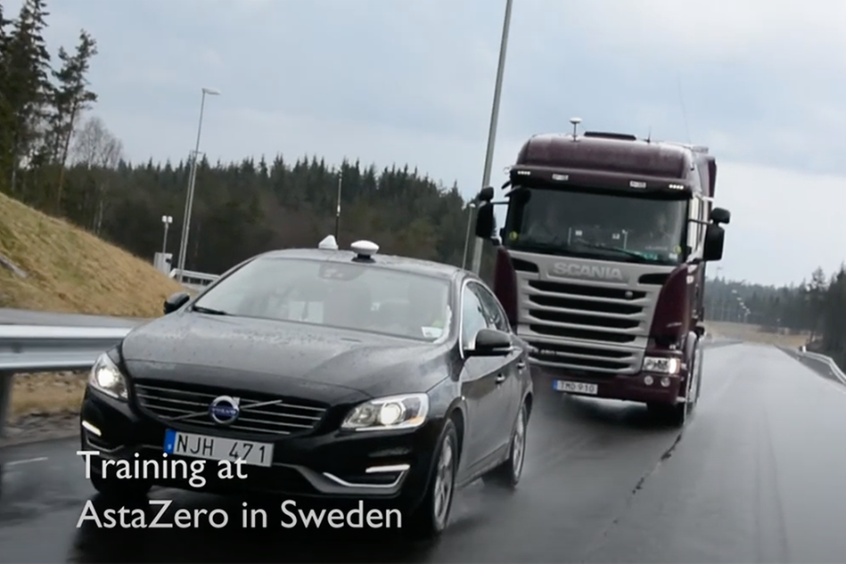 A truck driving behind a car on a wet road. Photo