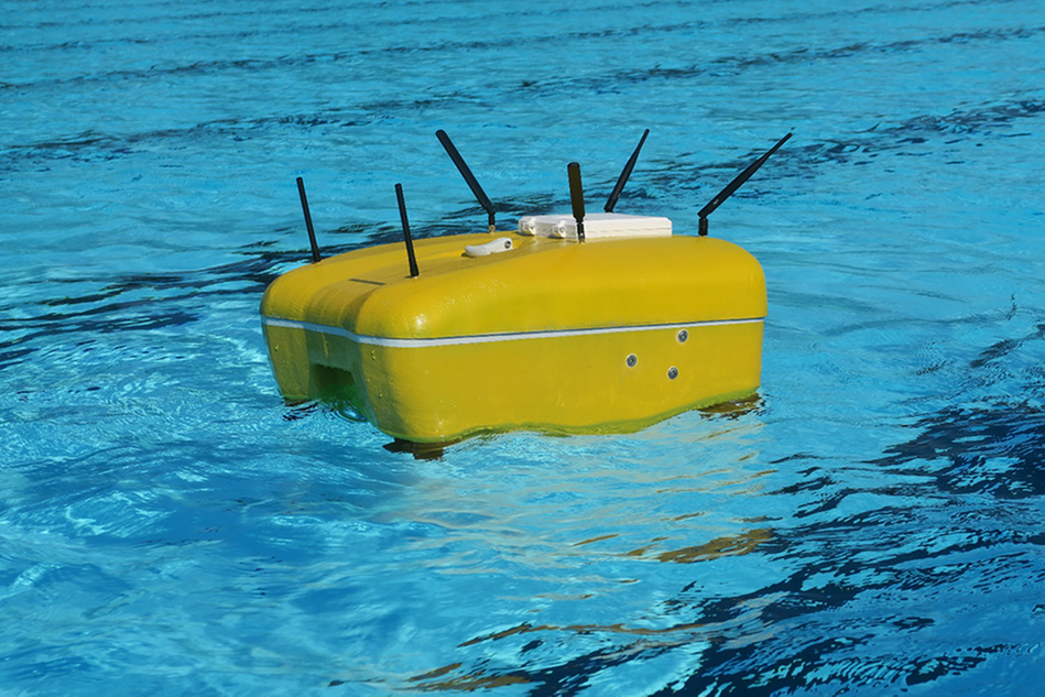En gul drönare flyter på vattenytan i en pool. Foto
