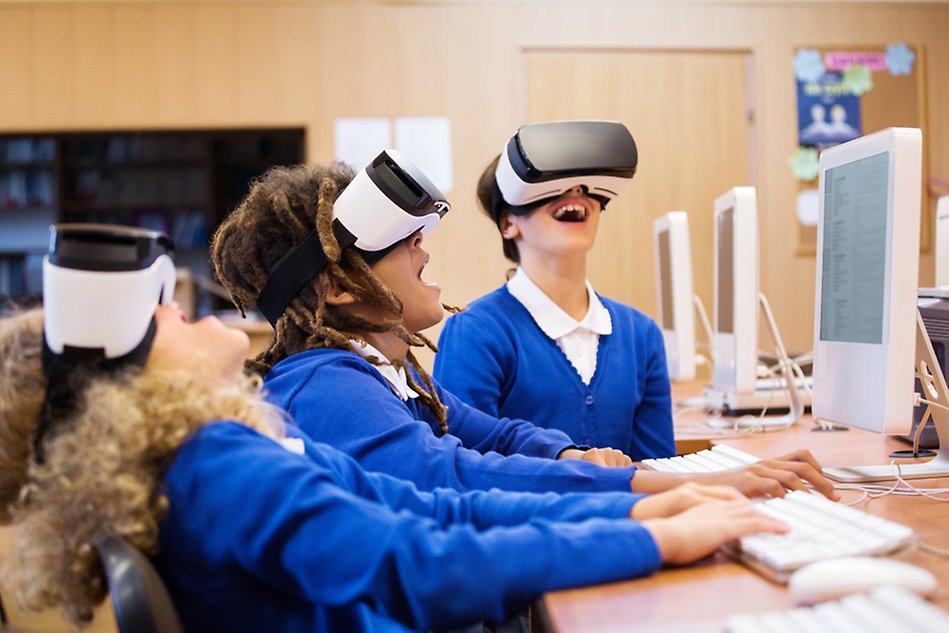 Three children in blue sweaters wearing VR-glasses.