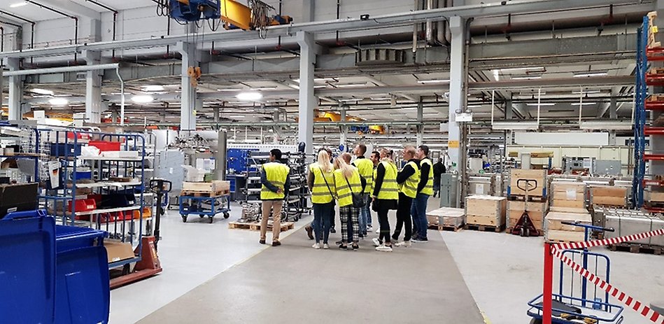 Personer i varselvästar i en industri.