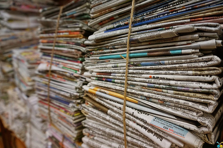 Piles of newspapers are stapled next to each other. Photo.