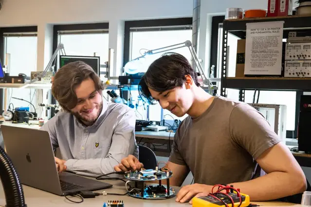 Två studenter arbetar med en prototyp i ett elektroniklabb.
