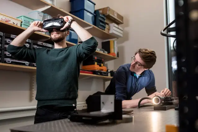 Två studenter testar VR-glasögon.